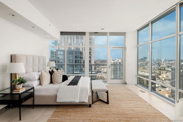 bedroom with expansive windows and light tile patterned flooring