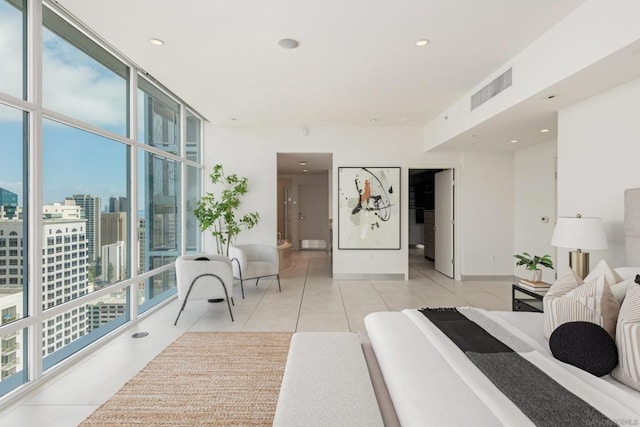 bedroom with floor to ceiling windows, multiple windows, and light tile patterned flooring