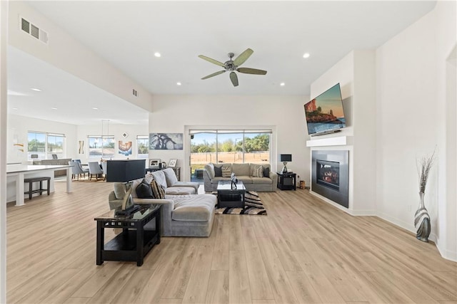 living room with ceiling fan and light wood-type flooring