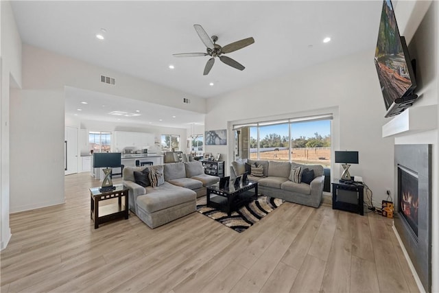 living room featuring ceiling fan and light hardwood / wood-style flooring