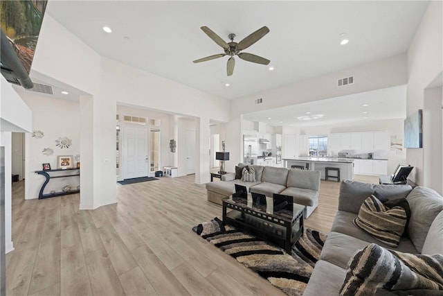 living room featuring ceiling fan and light hardwood / wood-style flooring