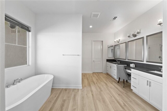 bathroom with vanity, hardwood / wood-style floors, and a tub