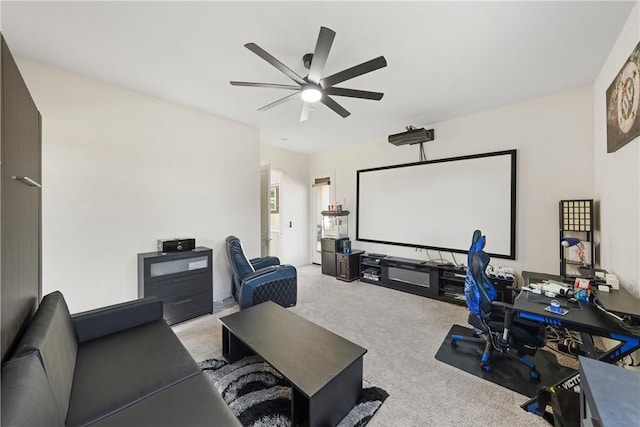 cinema room with ceiling fan and light colored carpet