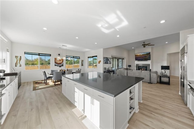 kitchen with light wood-type flooring, white cabinetry, and a center island