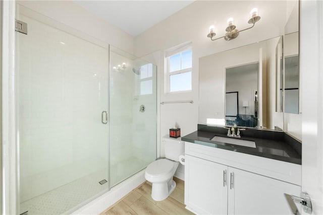 bathroom with vanity, toilet, hardwood / wood-style flooring, and walk in shower