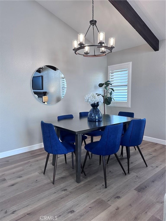 dining space featuring light hardwood / wood-style flooring, beamed ceiling, and a notable chandelier