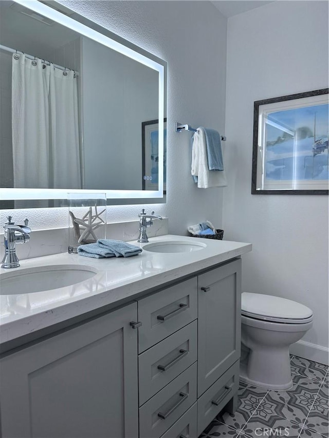 bathroom with toilet, tile patterned floors, vanity, and curtained shower