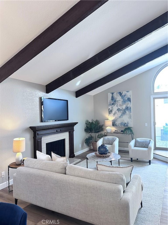 living room with lofted ceiling with beams, a brick fireplace, and hardwood / wood-style floors