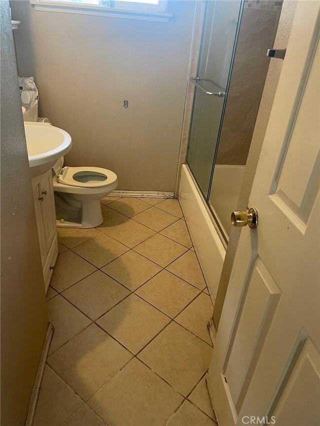 full bathroom featuring bath / shower combo with glass door, toilet, vanity, and tile patterned flooring