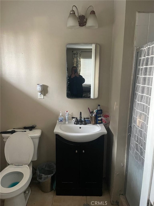 bathroom featuring toilet, vanity, an enclosed shower, and tile patterned flooring