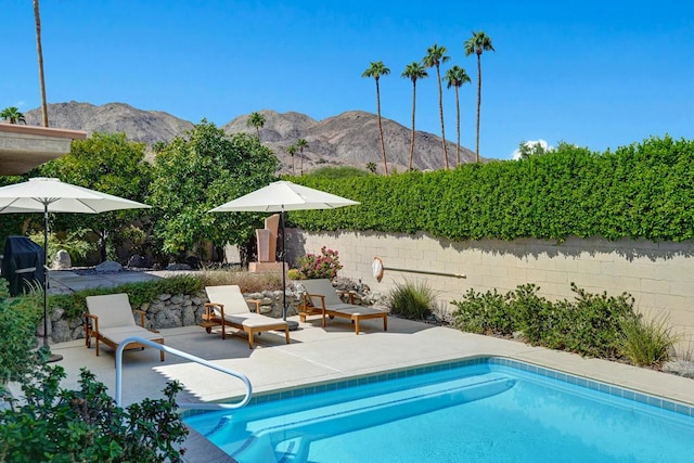 view of swimming pool featuring area for grilling and a mountain view