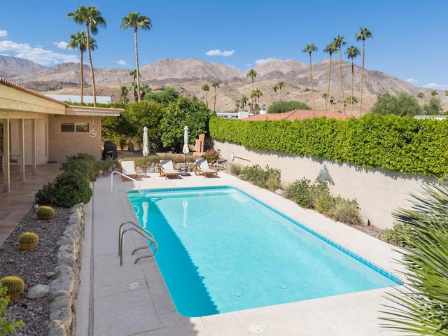 view of swimming pool with a patio area and a mountain view