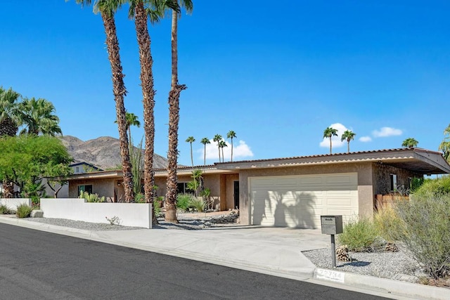 ranch-style house with a garage and a mountain view