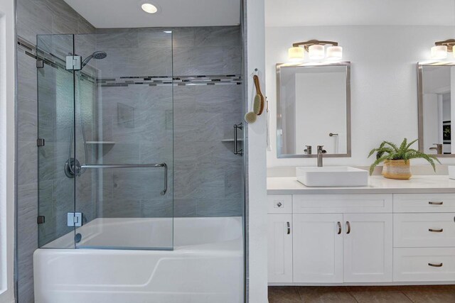 bathroom with tile patterned flooring, vanity, and bath / shower combo with glass door