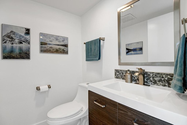 bathroom with tasteful backsplash, vanity, and toilet