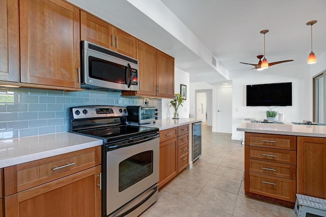 kitchen with pendant lighting, decorative backsplash, light tile patterned floors, ceiling fan, and stainless steel appliances