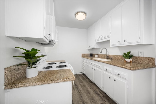 kitchen featuring white appliances, white cabinetry, light stone counters, and sink