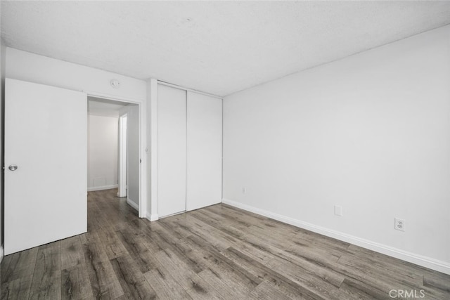 unfurnished bedroom featuring wood-type flooring and a closet