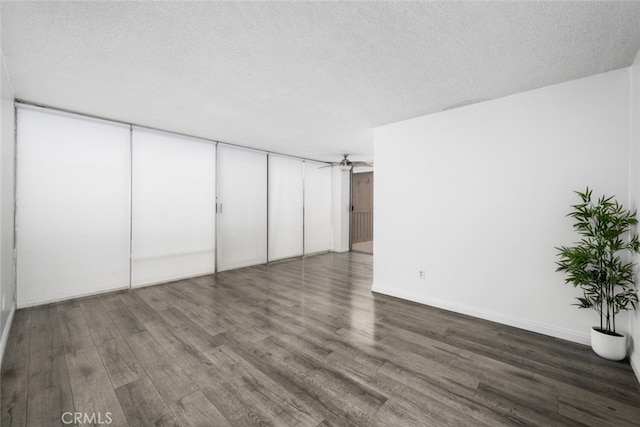 unfurnished bedroom featuring a textured ceiling and dark hardwood / wood-style flooring