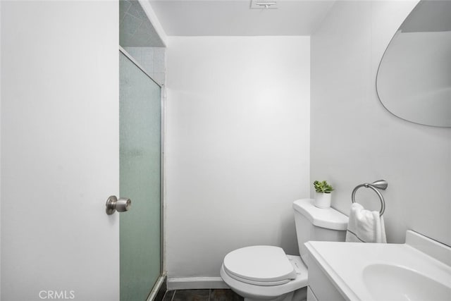 bathroom with tile patterned floors, toilet, a shower with door, and vanity