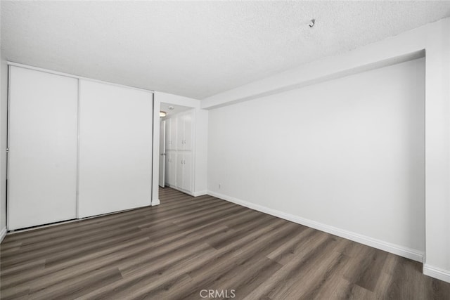 unfurnished bedroom featuring a closet, dark hardwood / wood-style flooring, and a textured ceiling