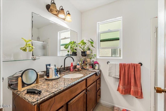 bathroom featuring tile patterned flooring, vanity, and walk in shower