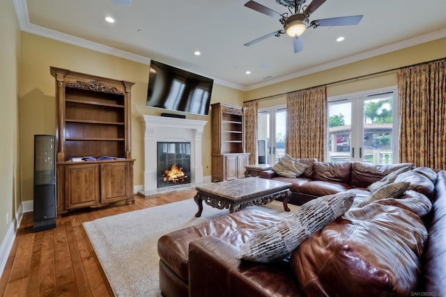 living room with crown molding, ceiling fan, and light hardwood / wood-style flooring