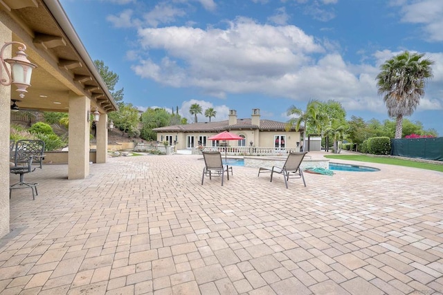 view of patio / terrace with ceiling fan and a fenced in pool