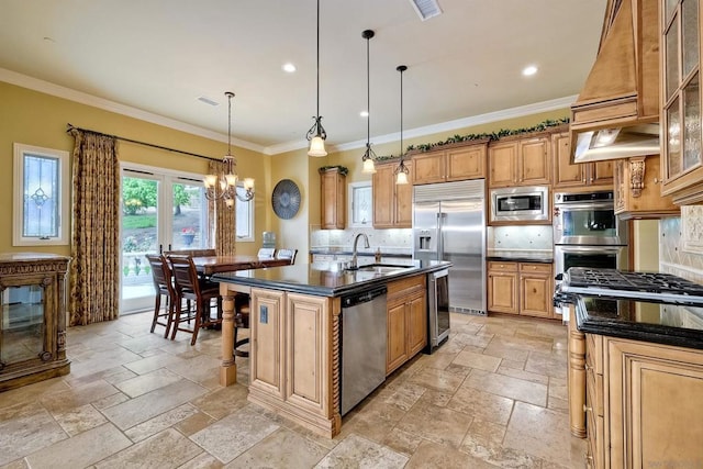 kitchen featuring built in appliances, premium range hood, a center island with sink, an inviting chandelier, and sink