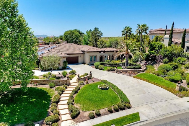 mediterranean / spanish-style house featuring a garage and a front lawn