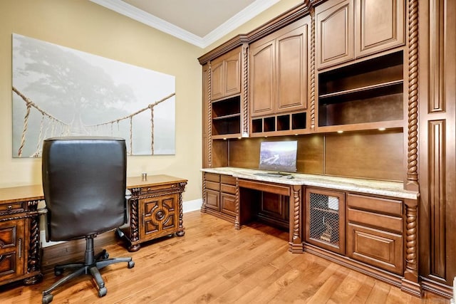 office space featuring built in desk, light hardwood / wood-style floors, and ornamental molding