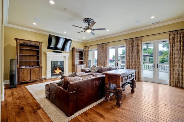 living room featuring ceiling fan, french doors, hardwood / wood-style floors, and crown molding