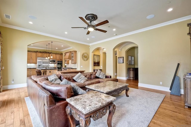 living room with light wood-type flooring and ornamental molding