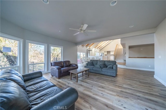 living room featuring ceiling fan, hardwood / wood-style flooring, and lofted ceiling with beams