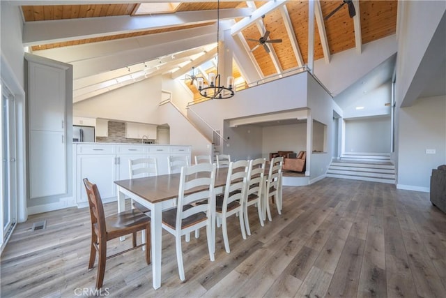 dining area with wooden ceiling, beam ceiling, light hardwood / wood-style flooring, and high vaulted ceiling