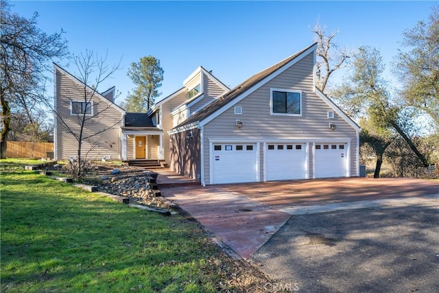 view of front of home with an attached garage, fence, concrete driveway, and a front yard