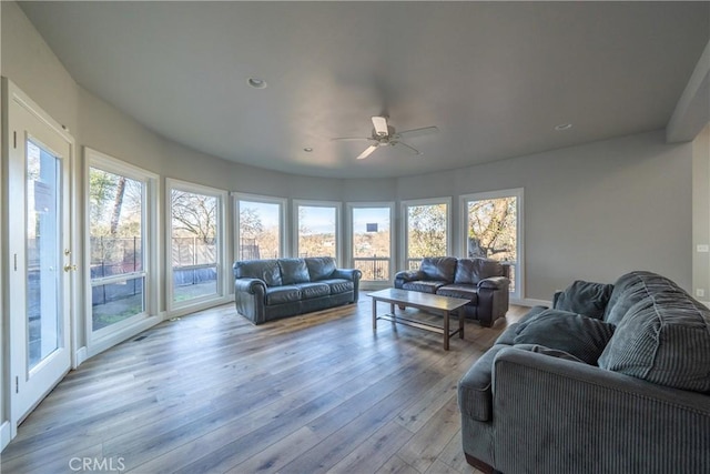 living area with light wood-type flooring, a ceiling fan, and recessed lighting