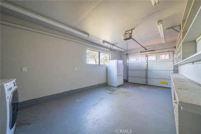 garage featuring a garage door opener, white fridge, and washer / clothes dryer