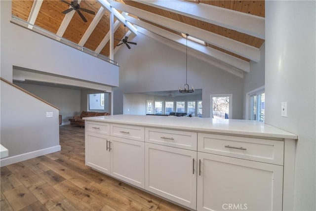 kitchen with wooden ceiling, white cabinetry, high vaulted ceiling, and decorative light fixtures