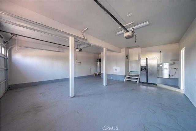 garage with stainless steel refrigerator with ice dispenser and a garage door opener