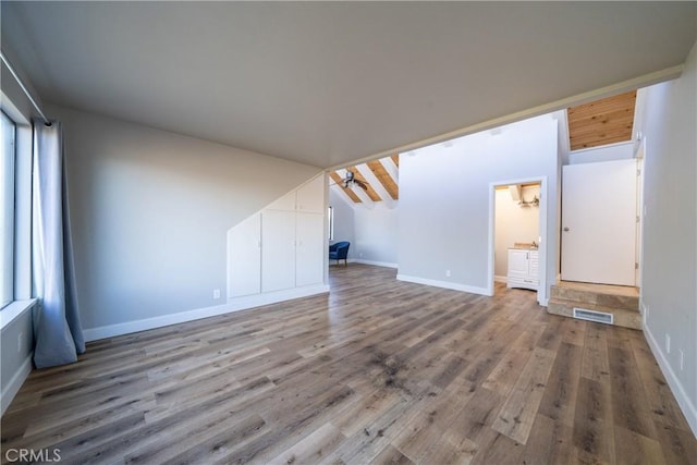 unfurnished living room featuring a ceiling fan, wood finished floors, visible vents, and baseboards