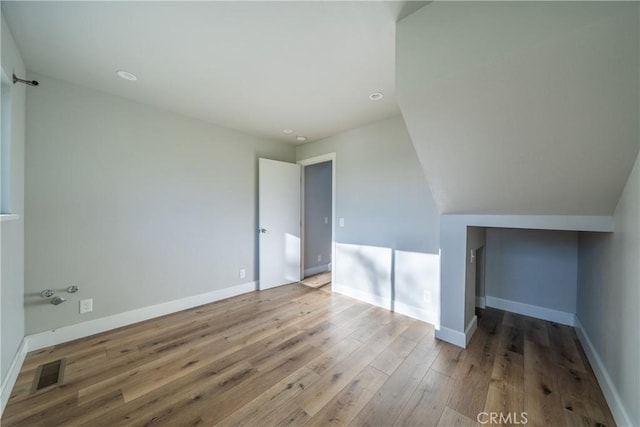 interior space with vaulted ceiling and light hardwood / wood-style flooring