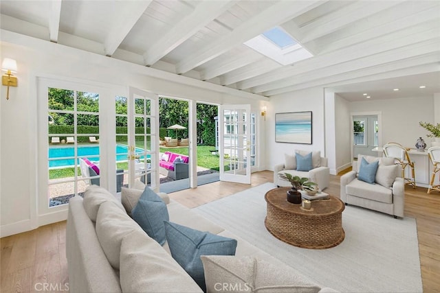 sunroom with beam ceiling, french doors, and a skylight