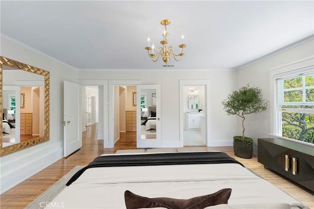 bedroom featuring an inviting chandelier, ornamental molding, connected bathroom, and light hardwood / wood-style flooring