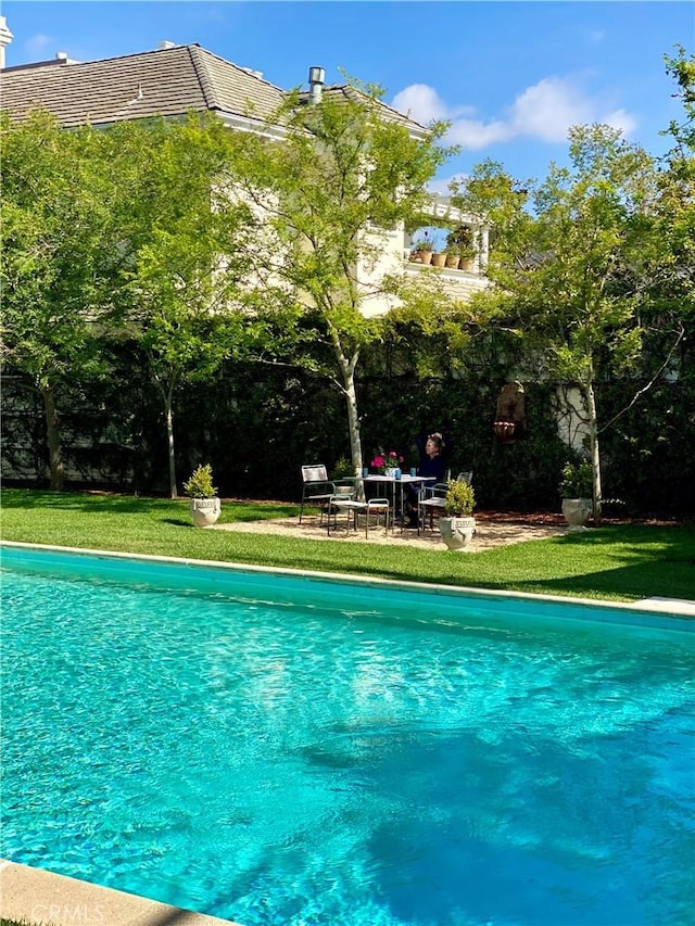 view of pool with a yard