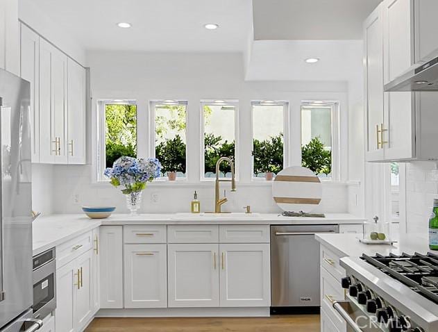 kitchen with stainless steel dishwasher, white cabinets, and sink