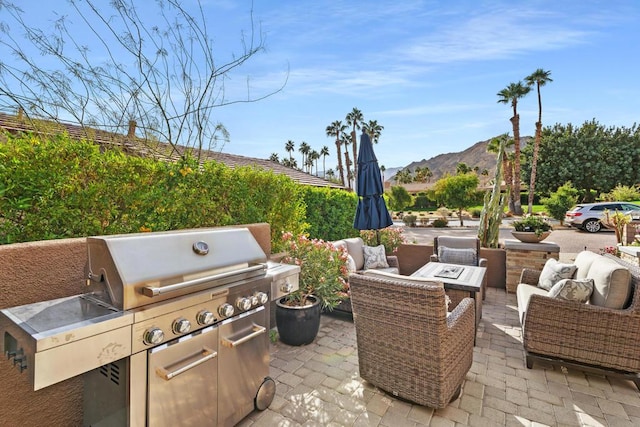 view of patio with a grill, a mountain view, and outdoor lounge area