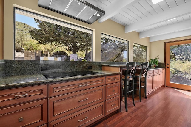 kitchen featuring black electric stovetop, wooden ceiling, dark hardwood / wood-style floors, beamed ceiling, and dark stone counters