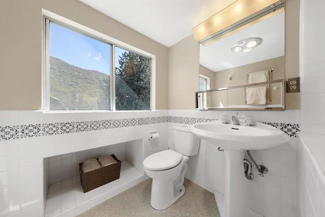 bathroom featuring a mountain view, tile walls, and toilet