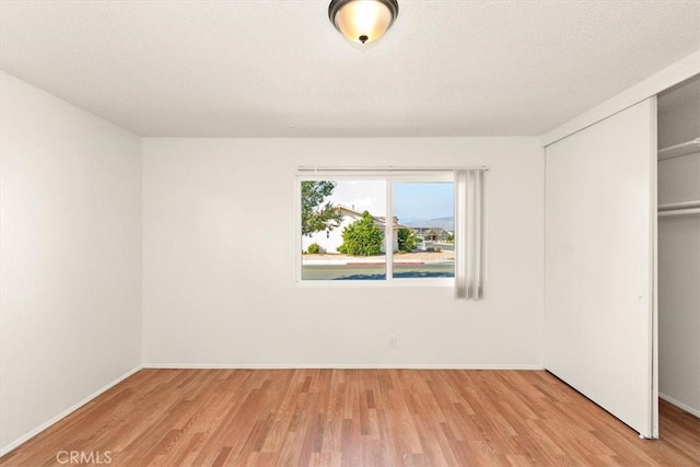 unfurnished bedroom featuring a closet and light hardwood / wood-style flooring